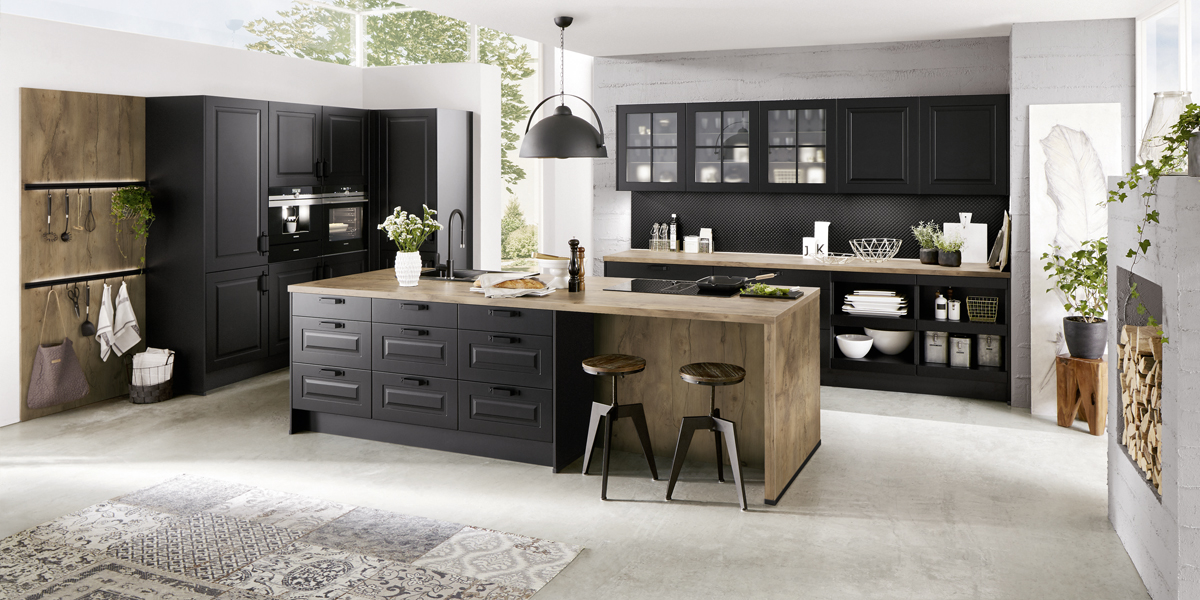 Zo ziet een eigentijdse landelijke stijl eruit: de karakteristieke paneelfronten werden heruitgevonden en zijn nu uiterst gestroomlijnd. Ze passen perfect bij moderne elementen in industriële stijl, die coole accenten zetten. Gelakte oppervlakken in donkere zwart- en antraciettinten en roestvrijstalen handgrepen geven uw keuken een zakelijk-technische uitstraling en vormen een spannend contrast met accessoires van natuurlijke materialen. 